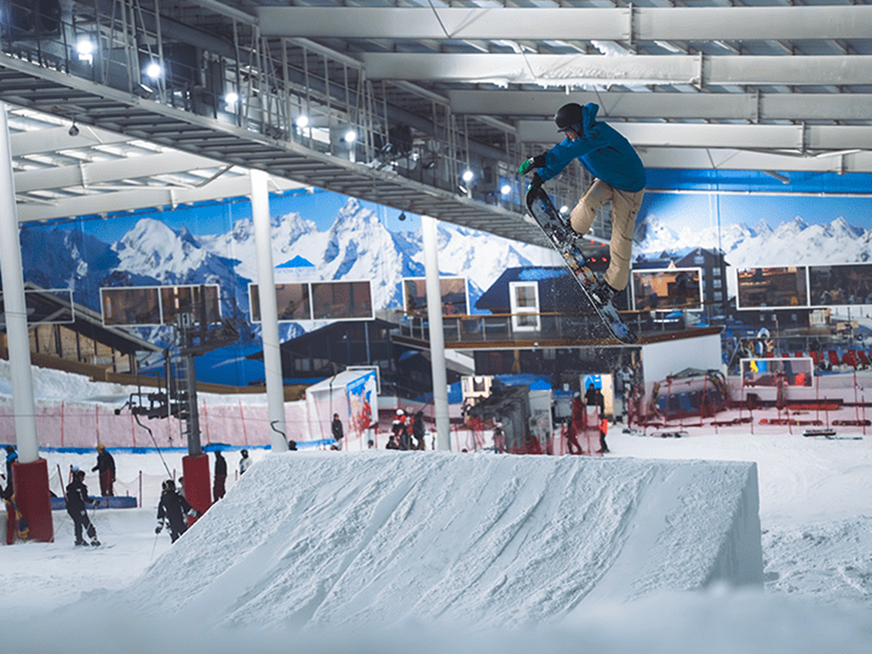 Snowboarder jumping behind a safety net