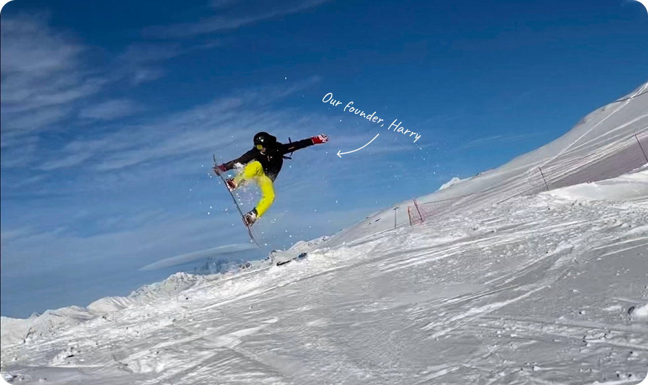 Skier riding over a rail with skis crossed